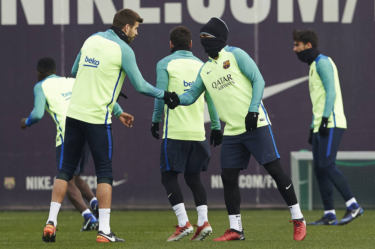 Los jugadores del Barcelona Gerard Piqué y Luis Suárez (d) se dan la mano durante el entrenamiento en la ciudad deportiva Joan Gamper. Barcelona necesita ganar para seguir en la Copa