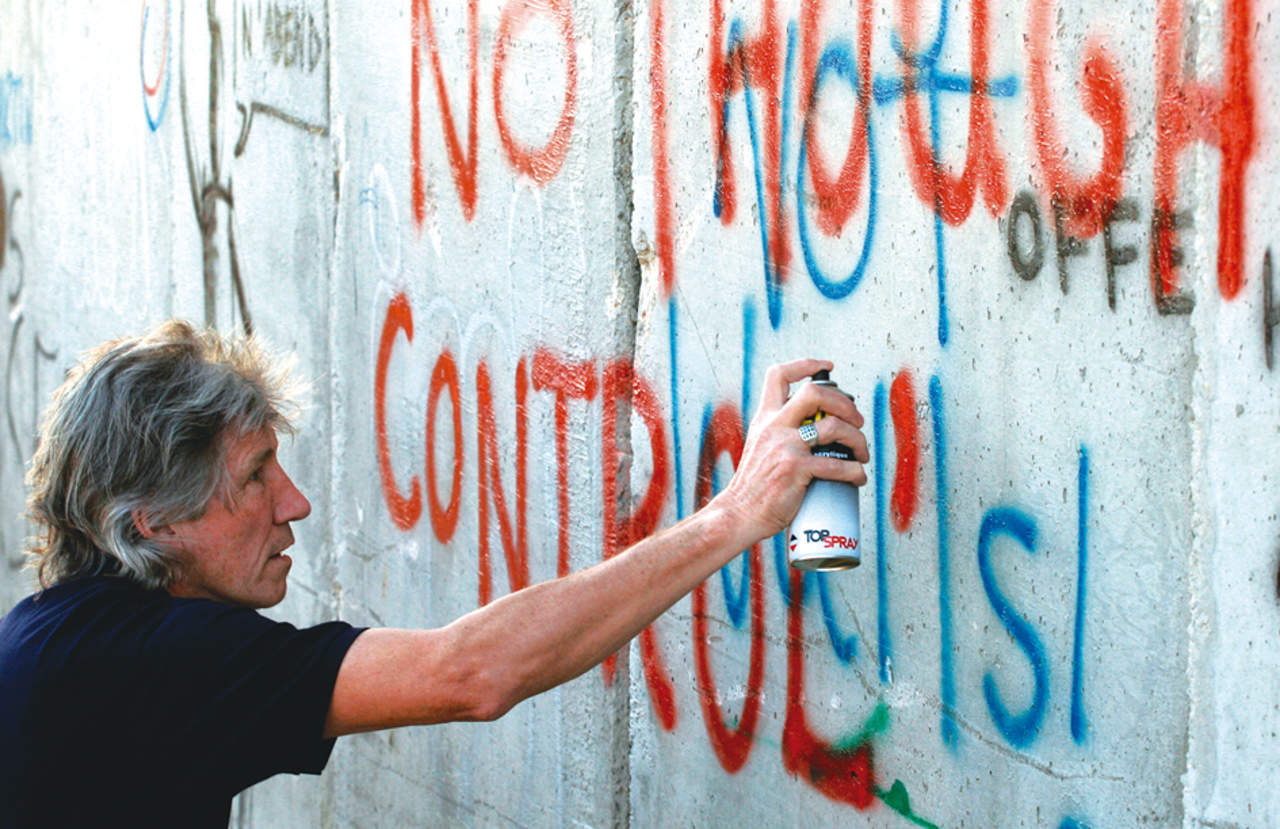Roger Waters escribiendo en la barrera de seguridad israelí-palestina en Gaza (2006). Foto:Getty