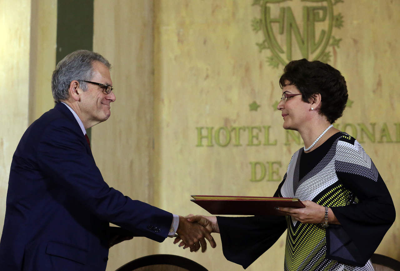 El jefe de la misión diplomática estadounidense firmó el acuerdo en representación de su país, mientras que por Cuba Marta Oramas. (EFE)
