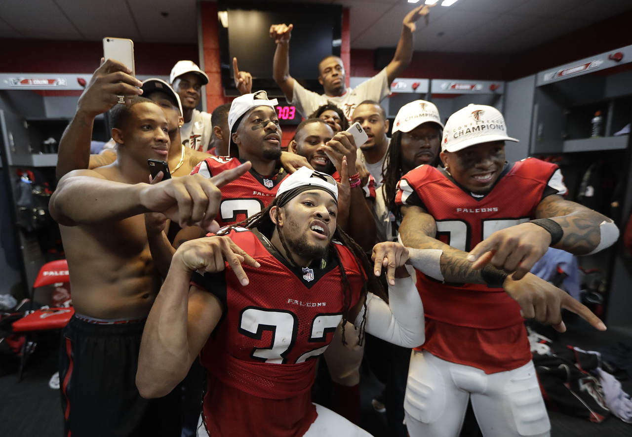 Jugadores de los Falcons celebrando en los vestidores, luego de ganar la final de la Conferencia Nacional.