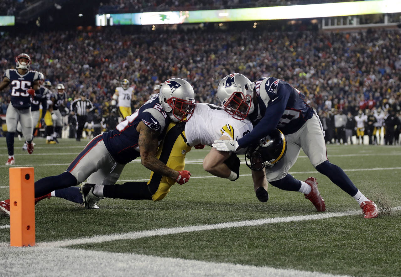 Defensivos de los Patriots impiden la anotación de Jesse James, en una jugada clave del partido. (AP)