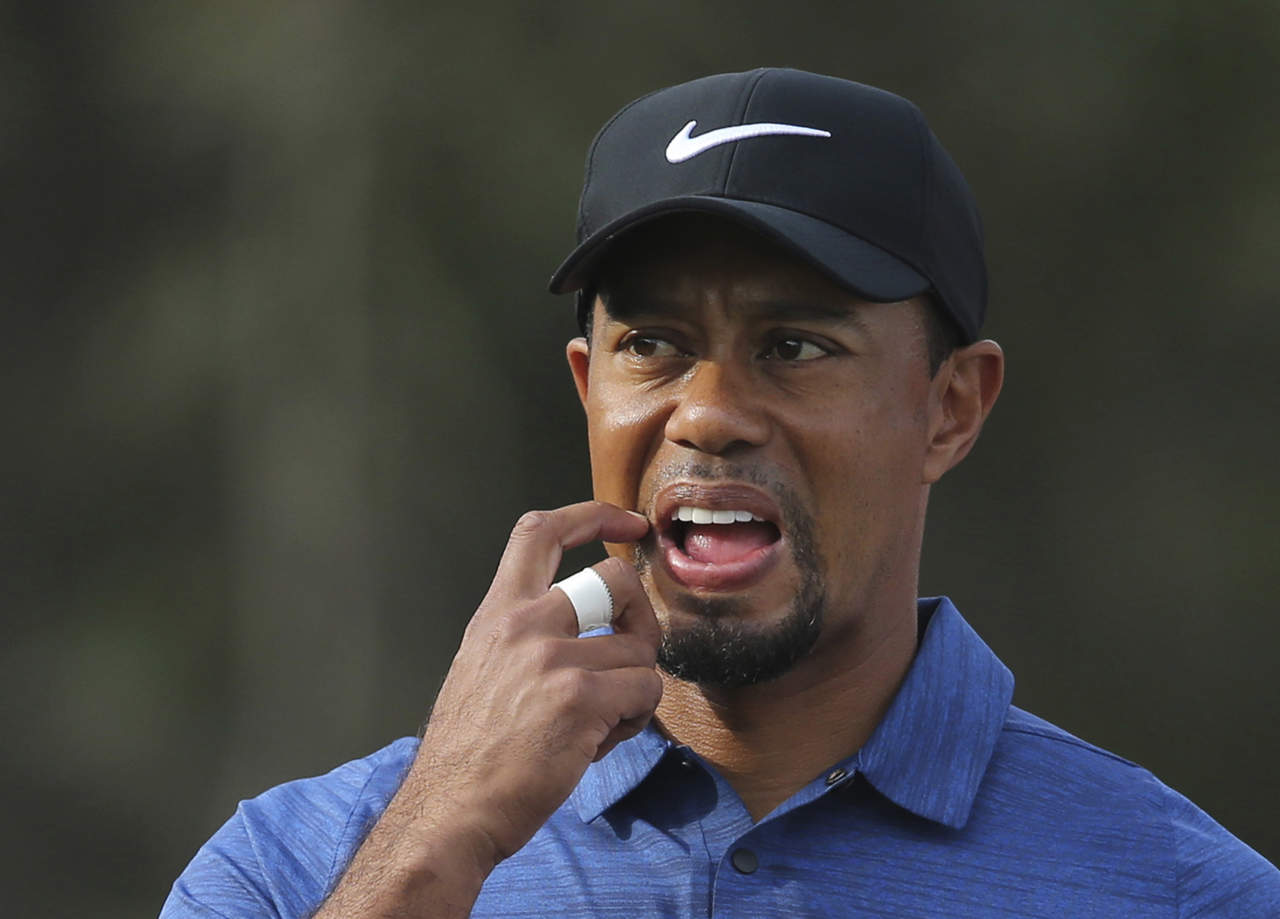 Tiger Woods, que tiró 77 golpes en la primer ronda, se retiró del torneo por espasmos en la espalda. (AP)