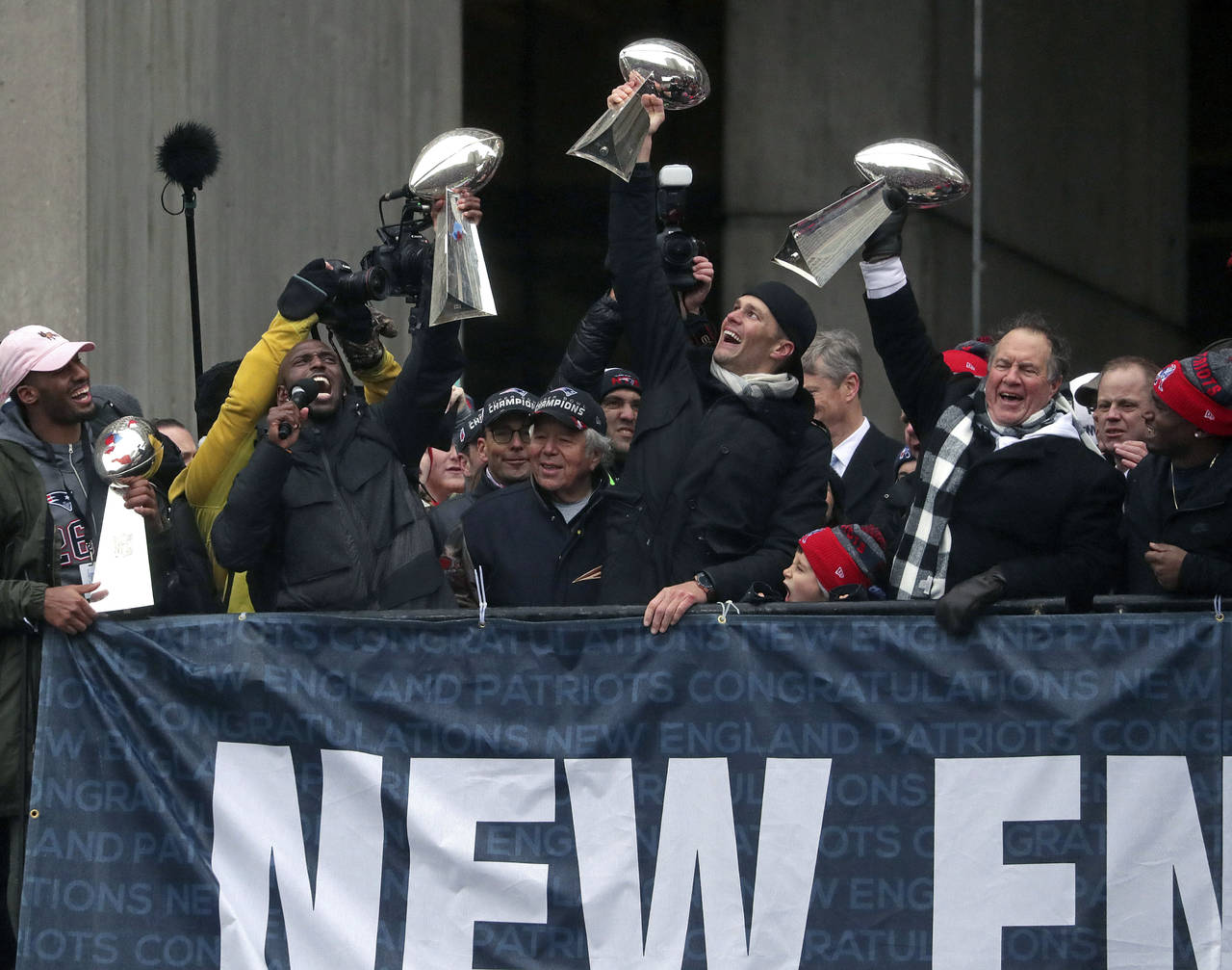 Tom Brady (c), Bill Belichick (d) y Devin McCourty levantan el trofeo Vince Lomardi durante el desfile de ayer. 