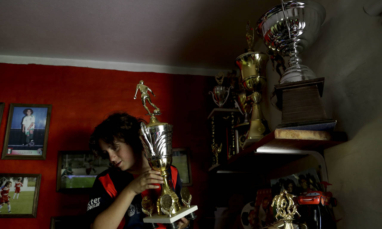 Thiago Perugini tiene su cuarto rodeado de trofeos y de fotografías de su ídolo, el astro Diego Armando Maradona. (AP)