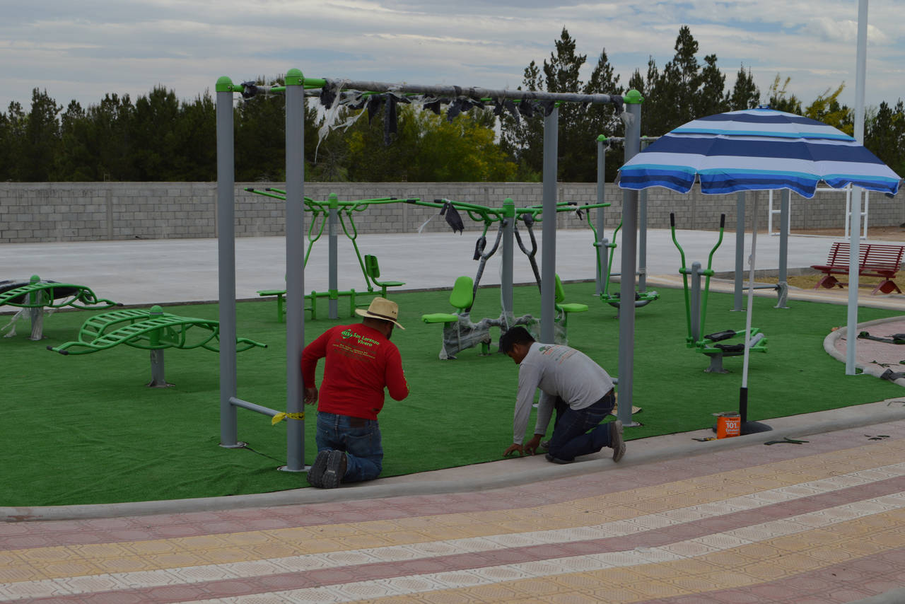 En marcha. Trabajadores municipales ya instalan el pasto artificial de la zona de juegos infantiles.