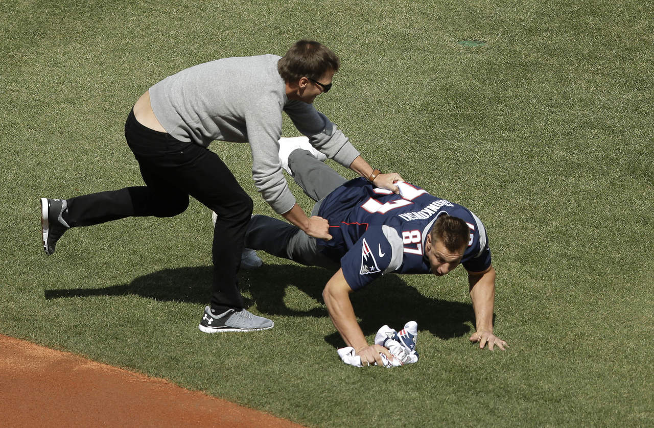 Tom Brady taclea a Rob Gronkowski para obtener de vuelta el jersey luego que el ala cerrada se lo había arrebatado. (AP)