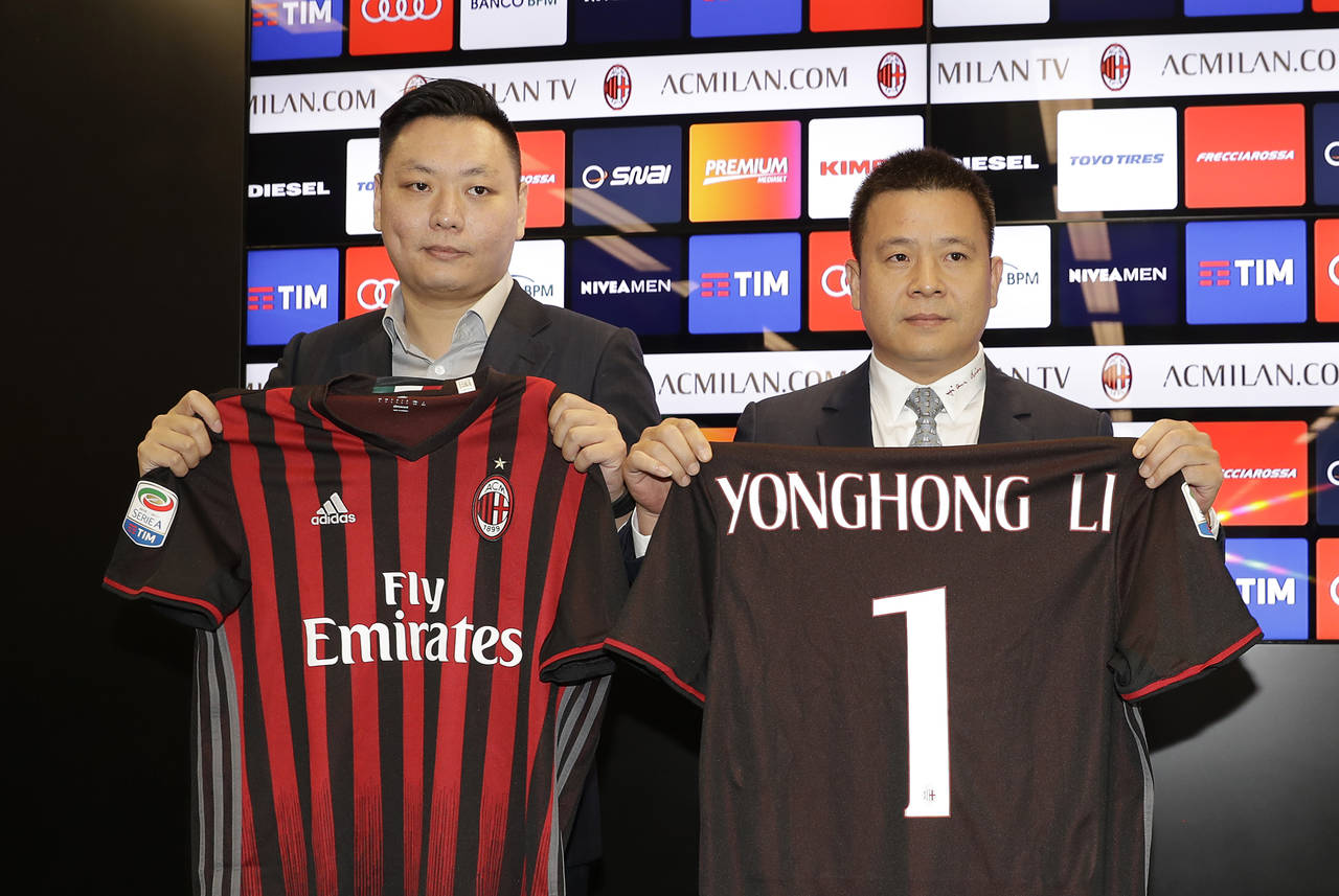 David Han Li (i) y Yonghong Li posan con los uniformes de Milán y representan una nueva época en el club. (AP)