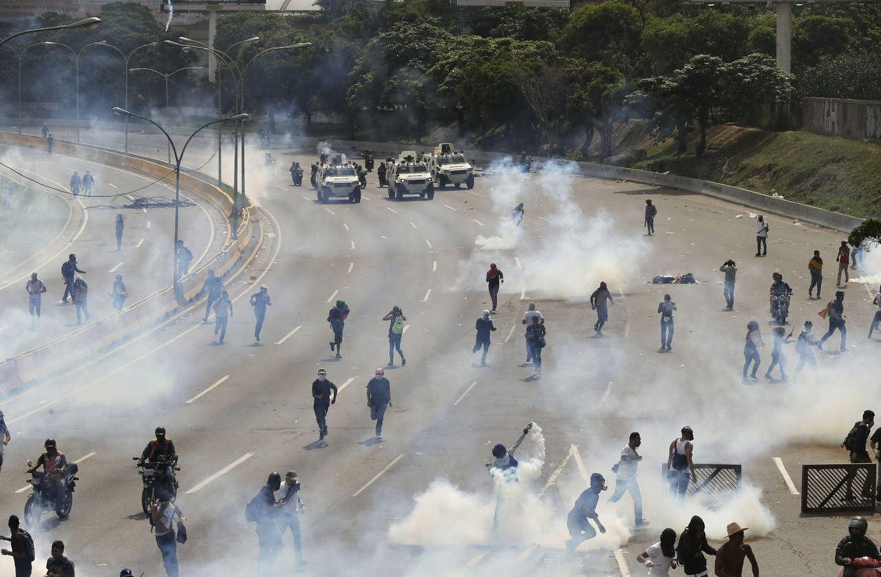 La masiva marcha fue contenida por un cordón de policía que comenzó rápidamente a arrojar bombas de gases lacrimógenos. (AP)