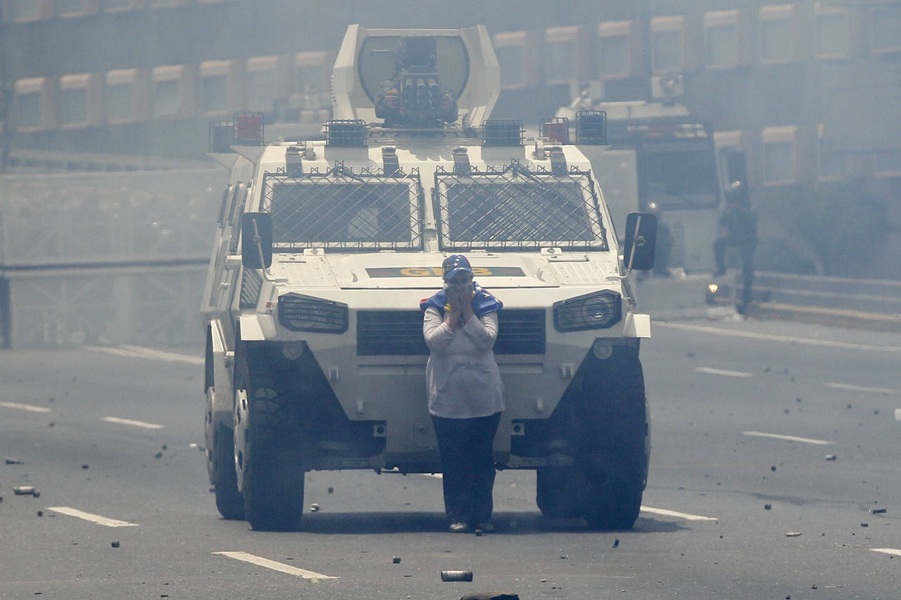 Defensa. Una de las participantes de manifestaciones en contra del gobierno de Nicolás Maduro, se puso enfrente una vehículo de la Guardia Nacional Bolivariana para bloquear su paso.