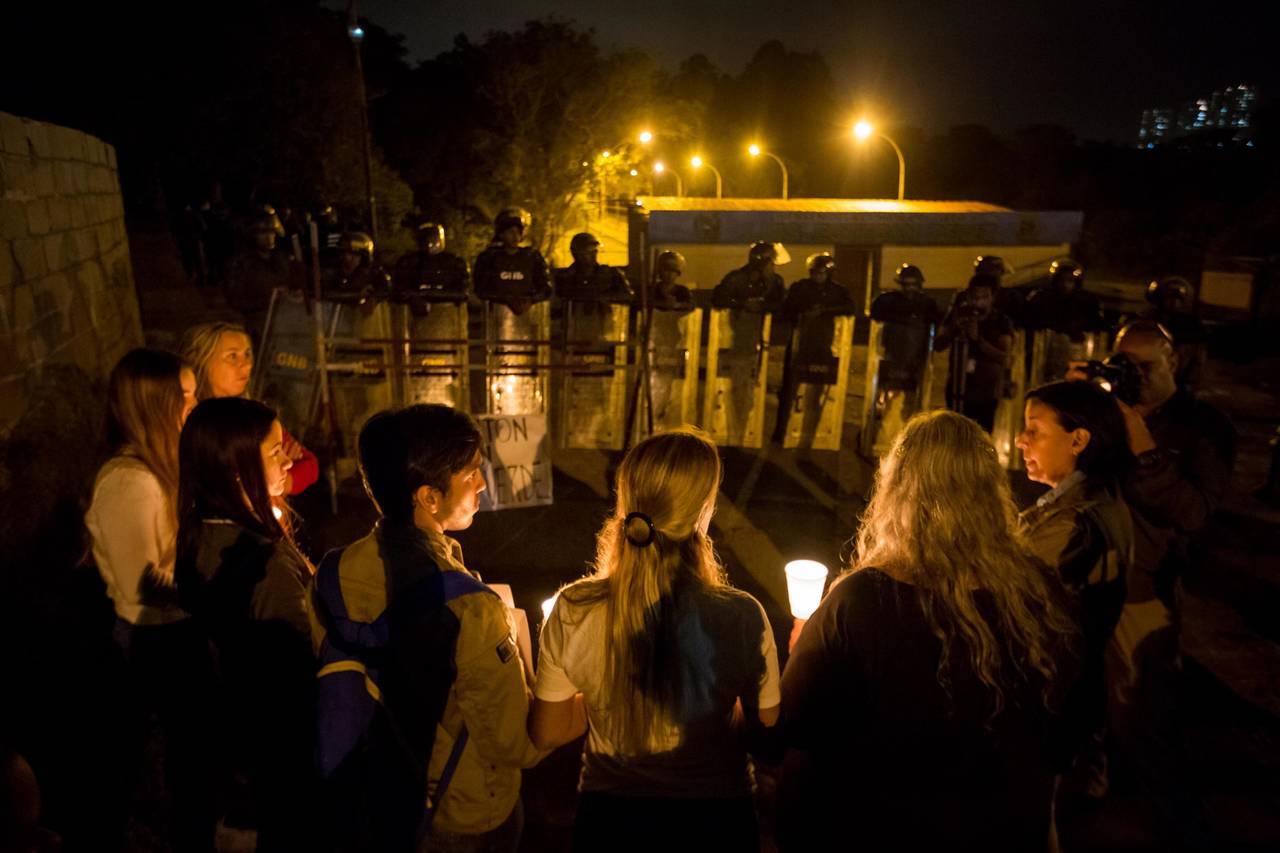 En contra. Un grupo de personas participa en una vigilia nocturna, afuera del penal militar.