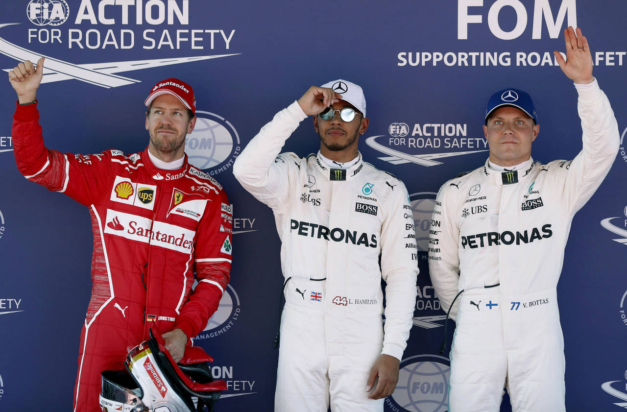 El británico Lewis Hamilton, del equipo Mercedes, celebra la primera posición junto a su compañero de equipo el piloto finlandés Valtteri Bottas. Hamilton largará primero