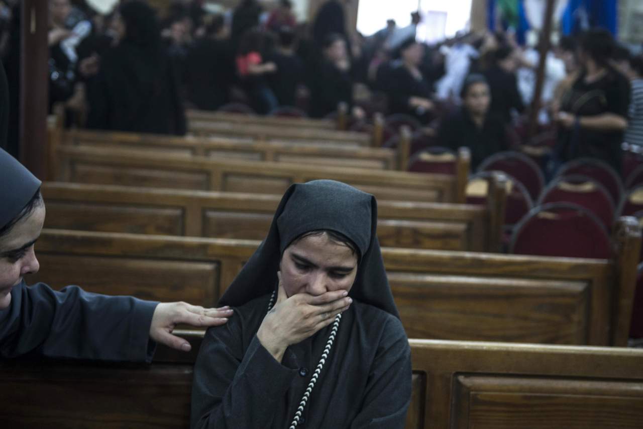 Indefensos.Una religiosa llora mientras es consolada durante el funeral de las víctimas.