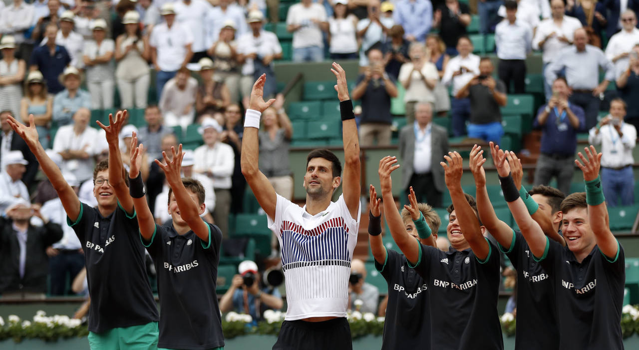 Novak Djokovic saluda junto a los niños recogepelotas tras un sufrido triunfo en París. (Fotografía de AP)