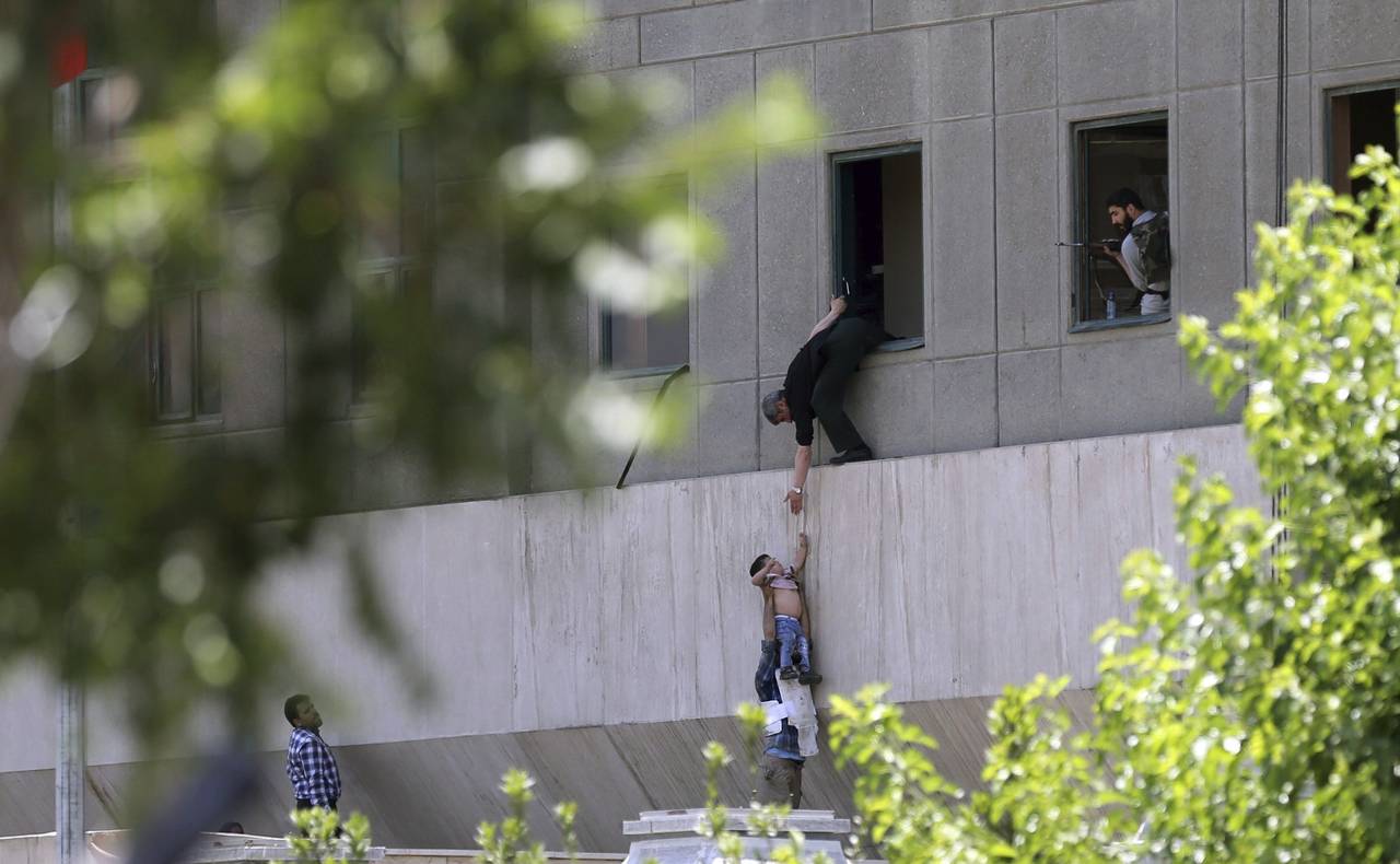 Escape.  Policías iraníes ayudan a escapar a civiles tras el ataque armado al Parlamento. 