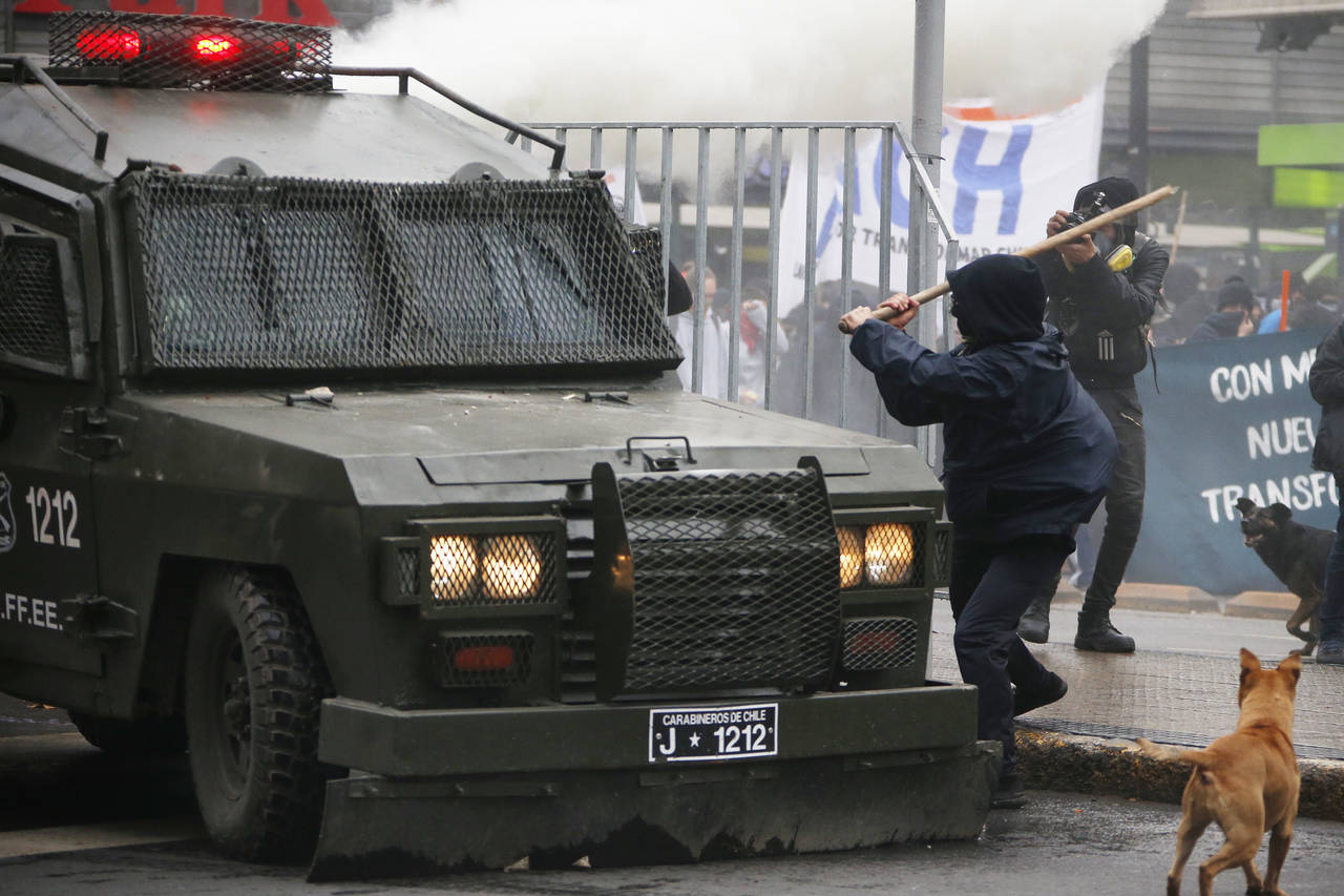 Combate. Un grupo de estudiantes que participaron en la marcha convocada por la Confech se enfrentó a la policía antidisturbios.