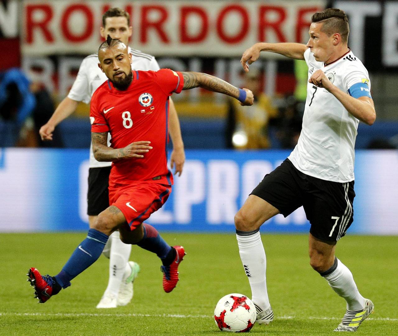 El alemán Julian Draxler (d) disputa el balón con el chileno Arturo Vidal (i) durante un partido del Grupo B. (EFE)