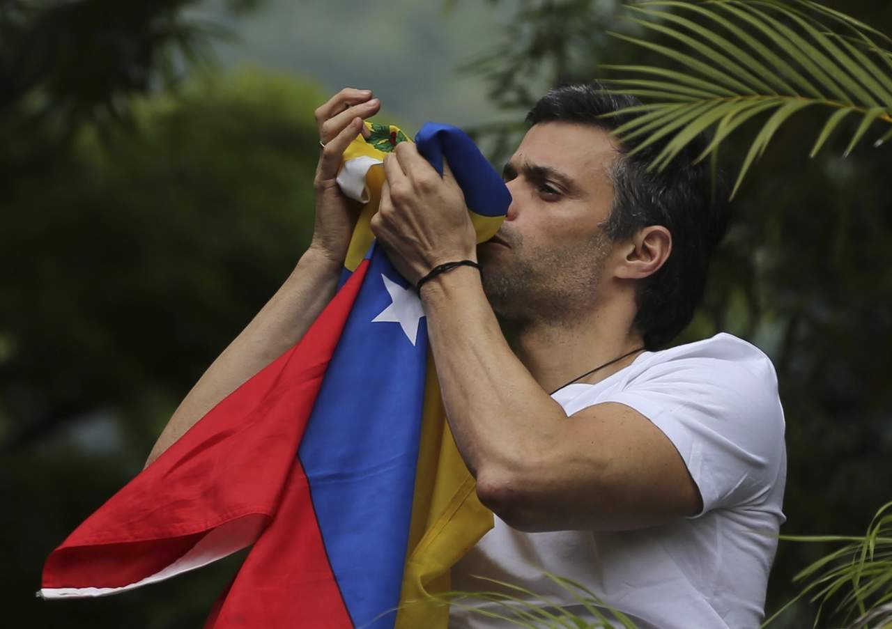 En una serie de fotografías difundidas en redes sociales y por The Associated Press, puede vérsele saludando, con una bandera venezolana en la mano, a la cual incluso besa. (AP)