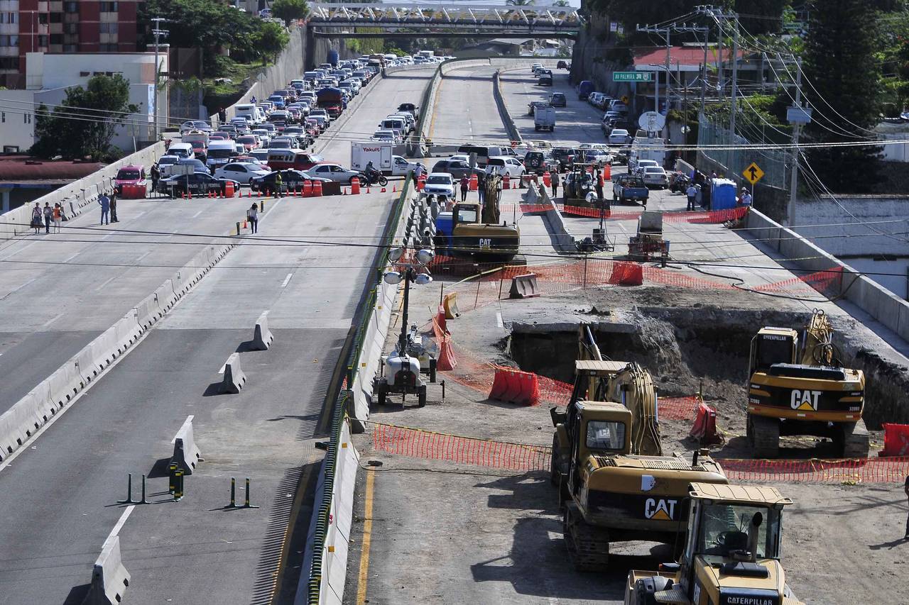 Molestia. El cierre de la Autopista México-Cuernavaca por las labores que peritos realizan en el área donde se abrió un socavón, generan caos vehicular en esta vía. (EL UNIVERSAL)