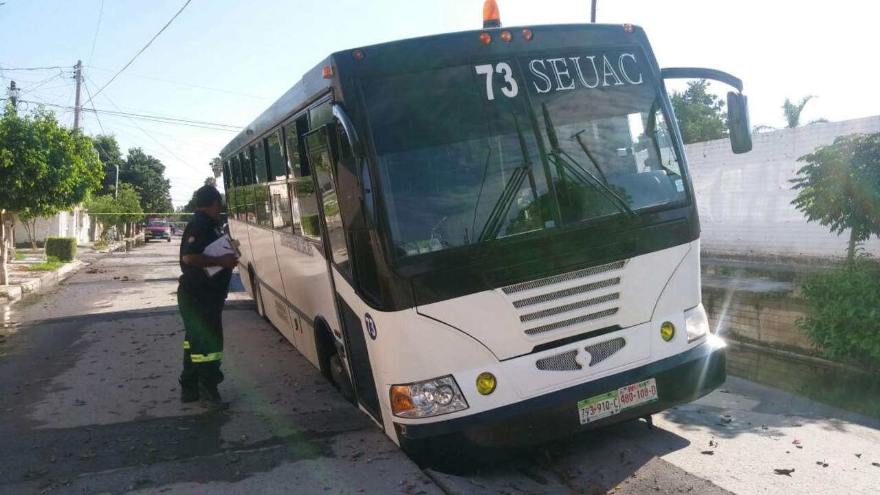 Autoridades de las diversas corporaciones de seguridad y rescate del municipio acudieron al lugar donde encontraron un autobús blanco de SEUAC con la llanta delantera derecha hundida en el colector. (EL SIGLO DE TORREÓN)