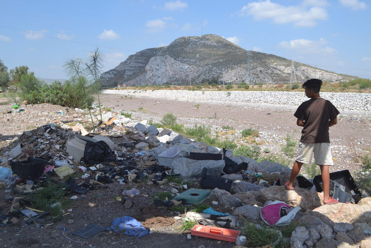 Entre la basura. 'Leo' tenía dos días esperando la avenida del río Nazas, del lado de Torreón. (ANGÉLICA SANDOVAL)
