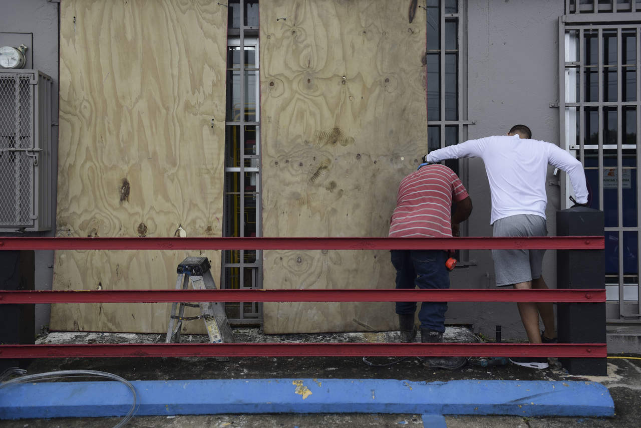 Puertorriqueños intentan proteger sus viviendas. (AP) 