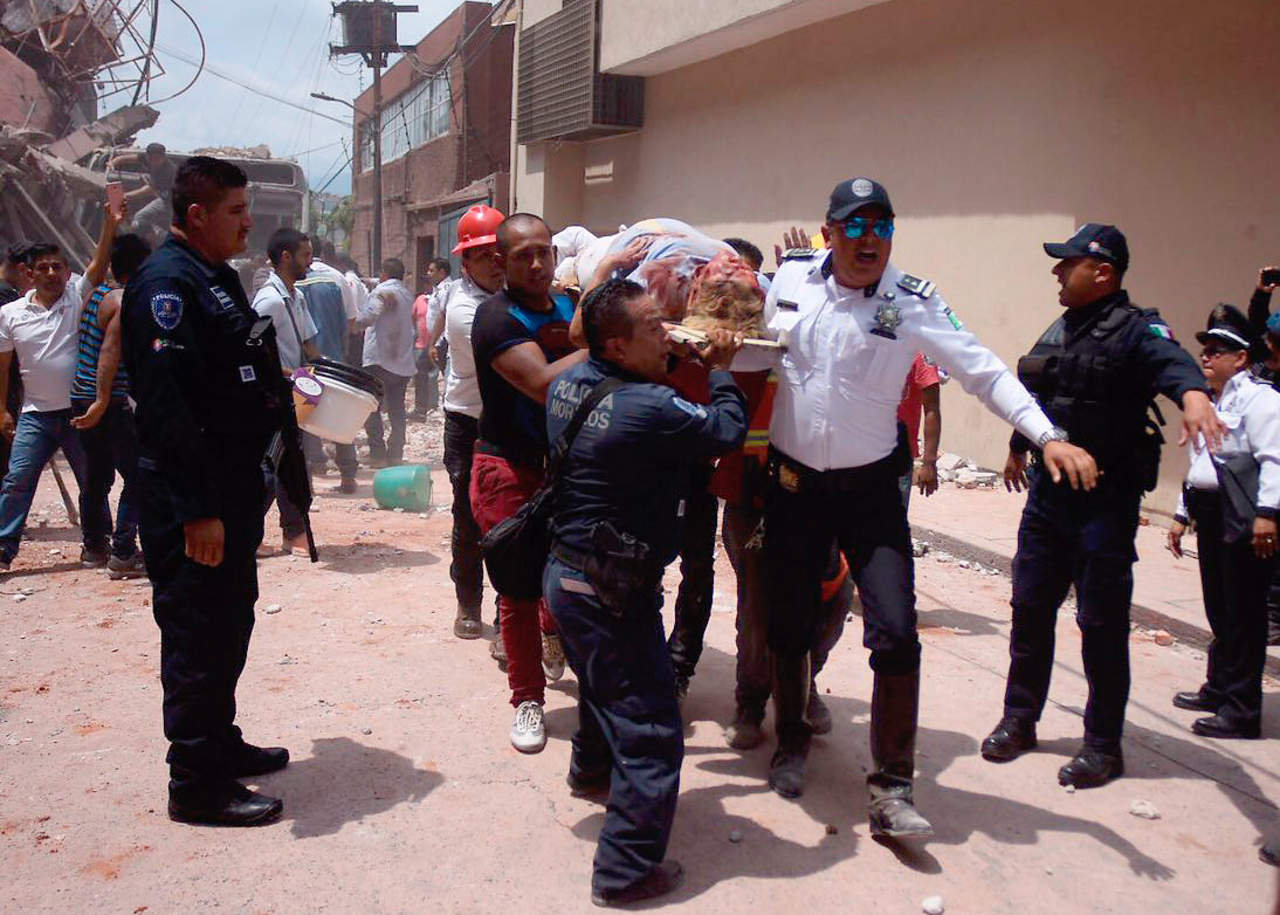 Auxilio. Rescatistas ayudan a mujer que se encontraba entre los escombros de los edificios colapsados en Cuernavaca, Morelos, estado del epicentro del sismo. (AGENCIAS)
