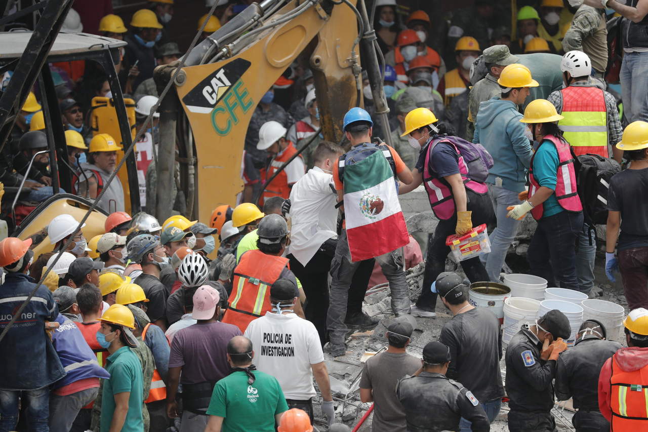 Trabajo en equipo. Grupos de rescate y voluntarios continuaban con las labores de búsqueda de desaparecidos bajo los escombros ayer en la Ciudad de México tras el sismo de magnitud 7.1 que ha cobrado la vida de decenas de personas. (EFE)