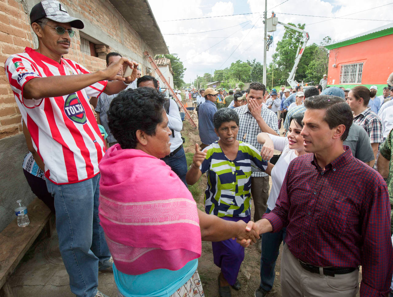 Visita. Enrique Peña Nieto recorrió una comunidad para supervisar las labores de apoyo.