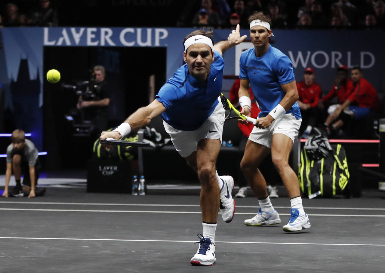 Roger Federer (i) y Rafael Nadal jugaron su primer partido de dobles como pareja. (AP)