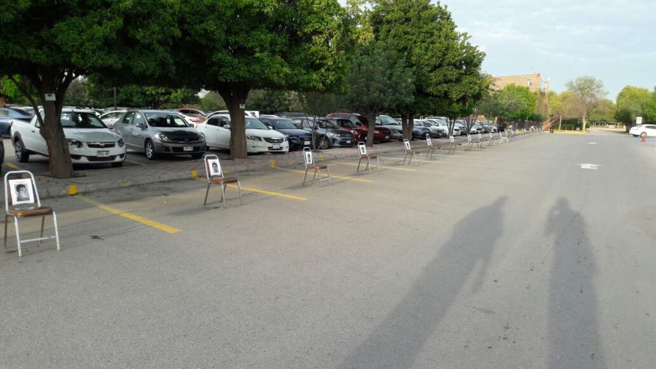 En la Universidad Iberoamericana, 43 cajones de estacionamiento fueron ocupados por sillas, que también tenían las fotografías de los normalistas. (EL SIGLO DE TORREÓN)