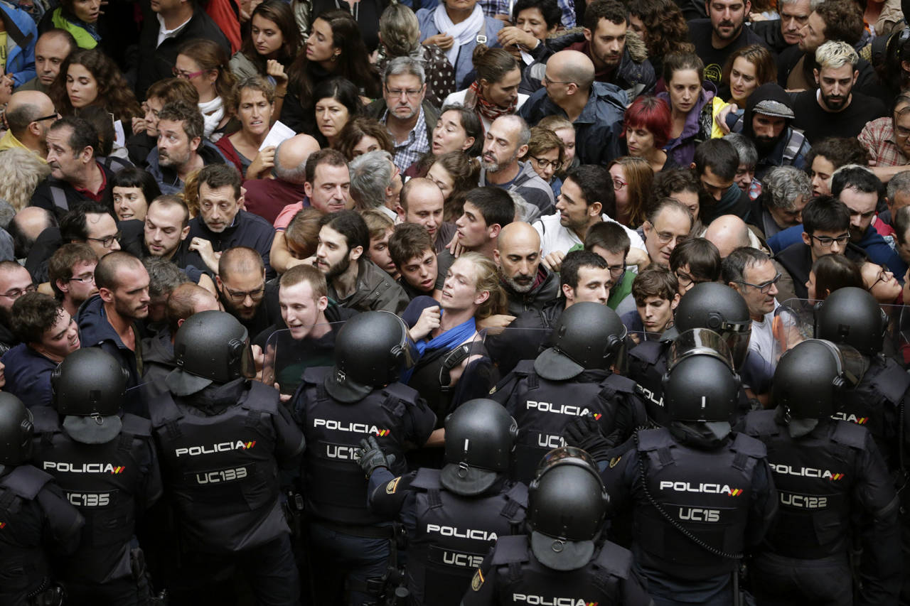 Choque. Miembros de la guardia nacional de España se enfrentaron a las participantes en el referéndum de Cataluña. (AP)