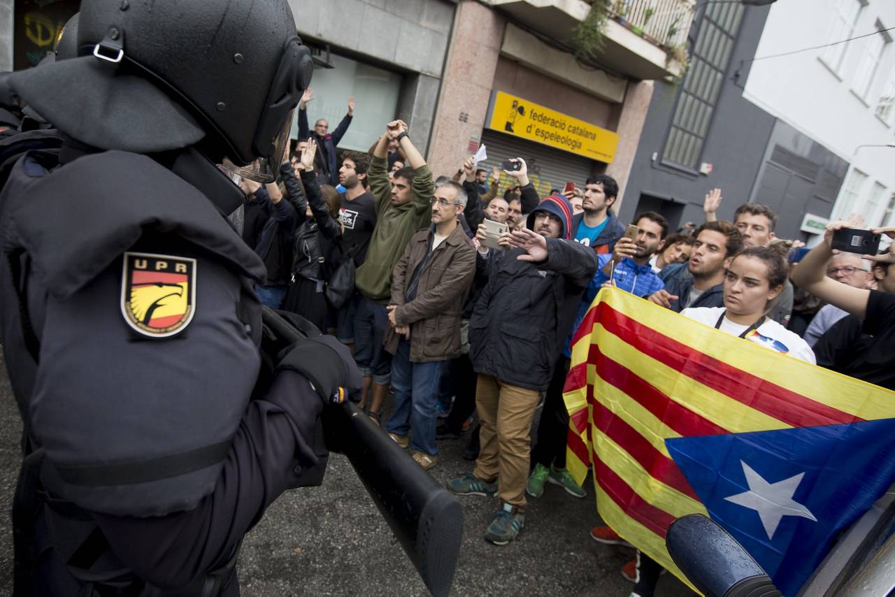 Frente a frente. En varias puntos de Cataluña, la guardia nacional golpeó a los participantes en el referéndum independentista. La tensión había crecido tanto en la calle que los agentes finalmente debieron replegarse entre cánticos de los ciudadanos. (AP y EFE)  