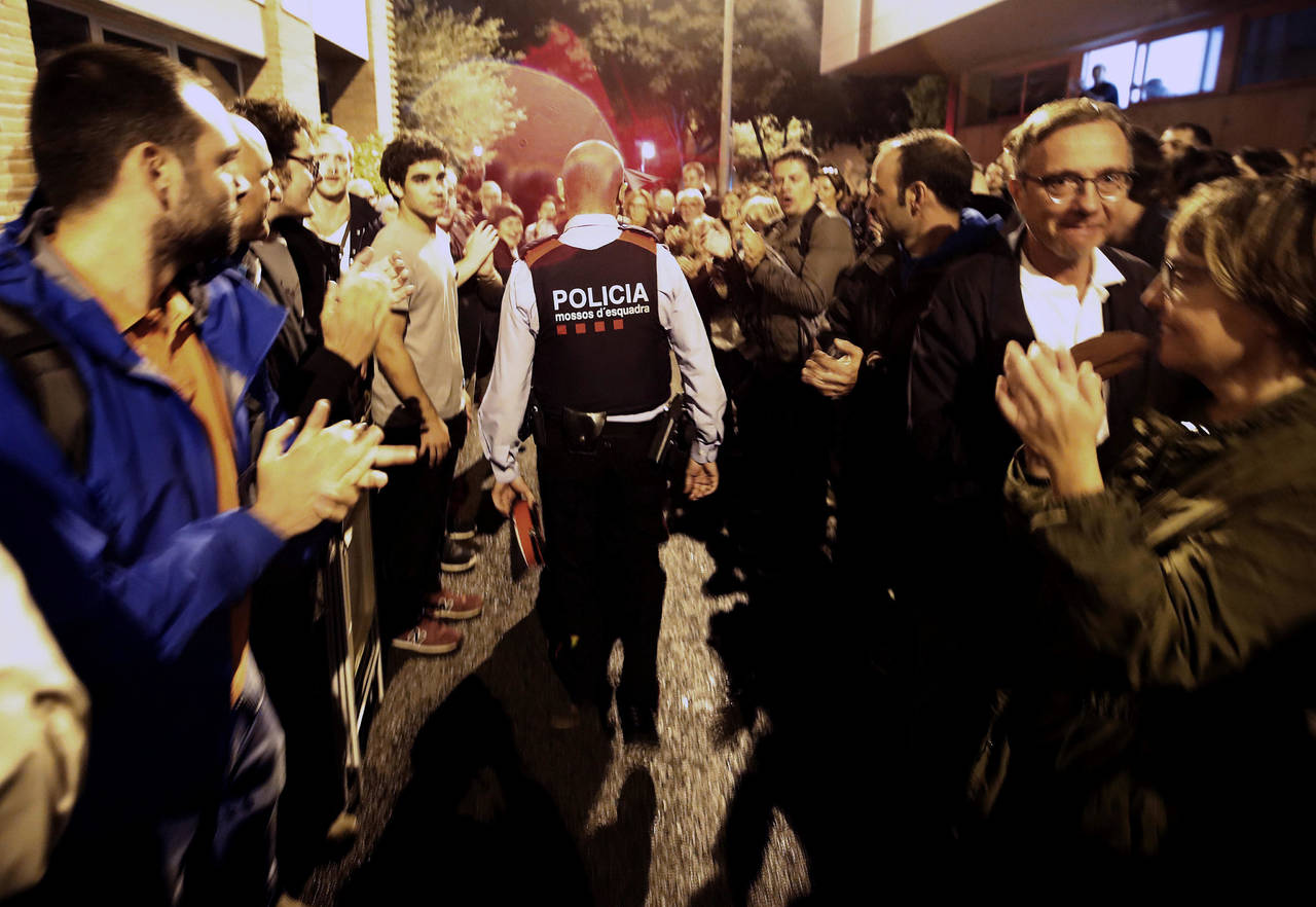 Se hacen a un costado. Miembros de los Mossos d'Esquadra, la policía de Cataluña, sólo levantaron actas en los centros de votación y se retiraron sin agredir o violentar a los votantes. (AP y EFE)  