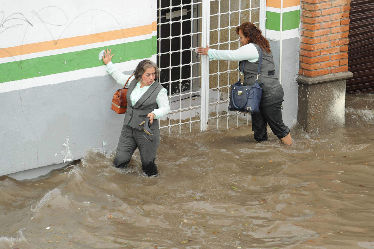 Ni Simas se salva. Empleadas del Simas tuvieron que mojar sus pies y ropa ante la cantidad de agua afuera de sus oficinas. (EL SIGLO DE TORREÓN)