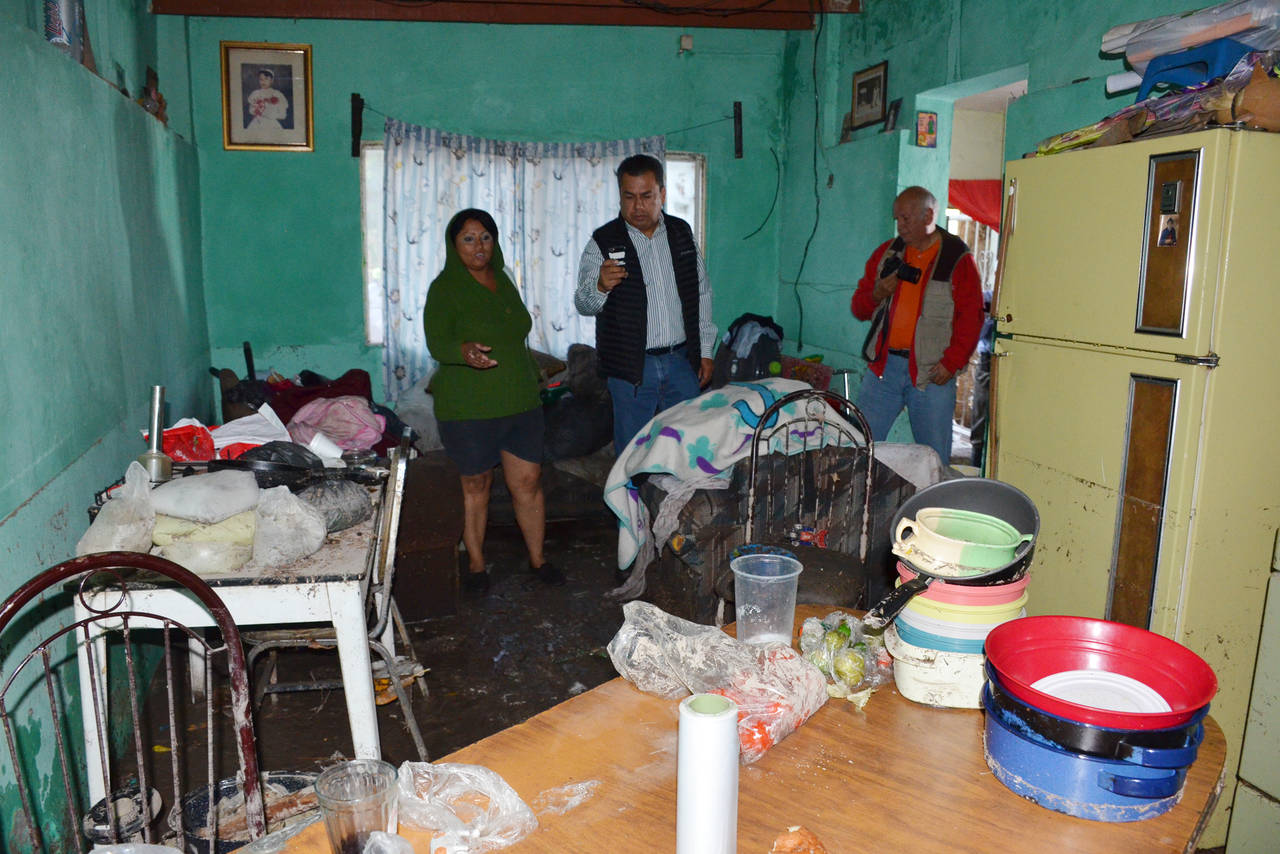 Daños. Rosario Leal  vecina de la calle Escuadrón 201 en la colonia Victoria, muestra al alcalde los daños que sufrió su vivienda  donde el agua alcanzó  altura superior a un metro. (FERNANDO COMPEÁN)