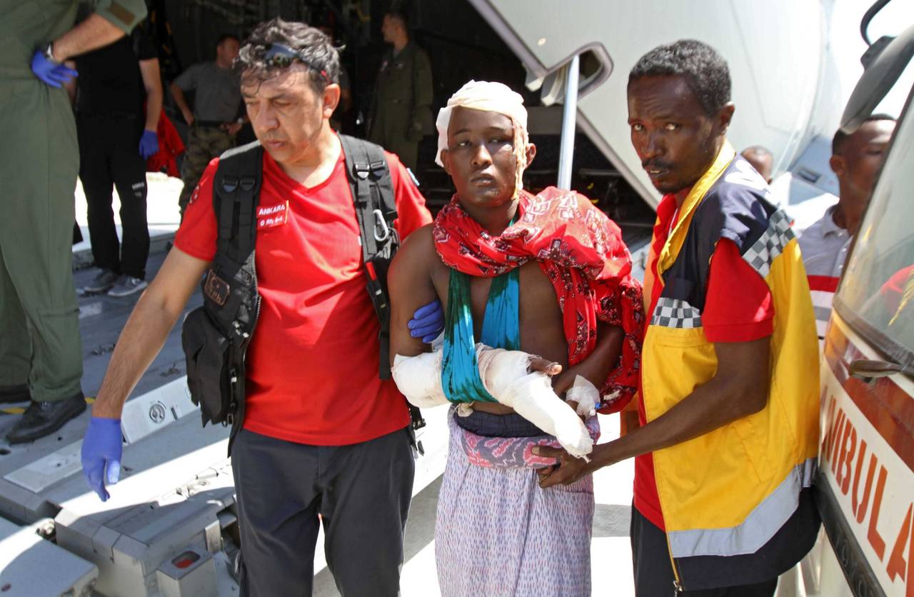 Transporte. Médicos turcos y somalís transportan a heridos a un avión militar que les transportará Turquía. (AGENCIAS)
