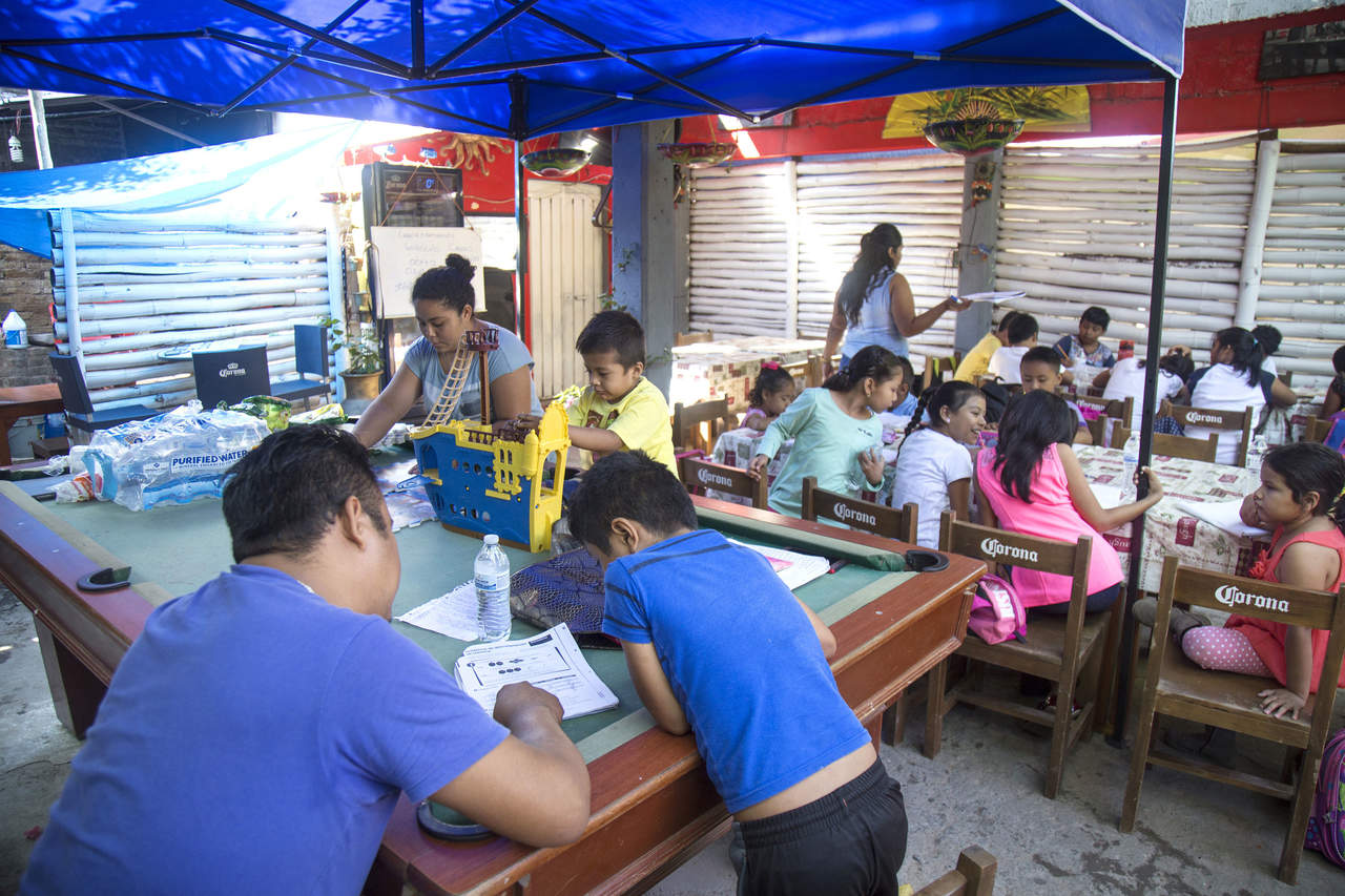 El restaurante-bar venido a escuela, conocido como Coco Bongo, inició con 18 alumnos y ahora alberga a 35 niños y niñas de 5 a 12 años, quienes toman clases en el patio del negocio. (EFE)