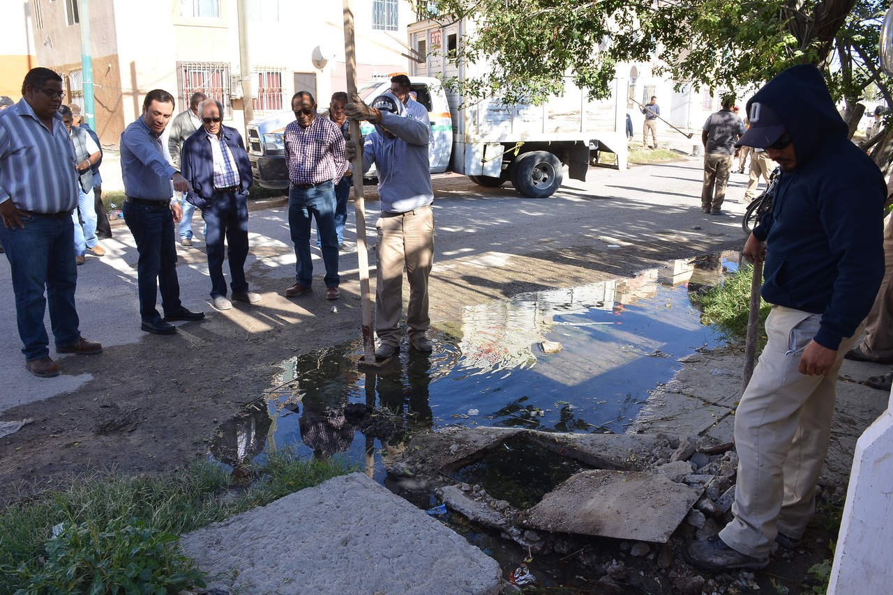 Recorrido. Xavier Herrera muestra a Juan José Gómez los charcos de aguas negras que se forman en las calles de Manhattan en Rincón La Merced, donde los vecinos tiran basura al drenaje. (FERNANDO COMPEÁN) 
