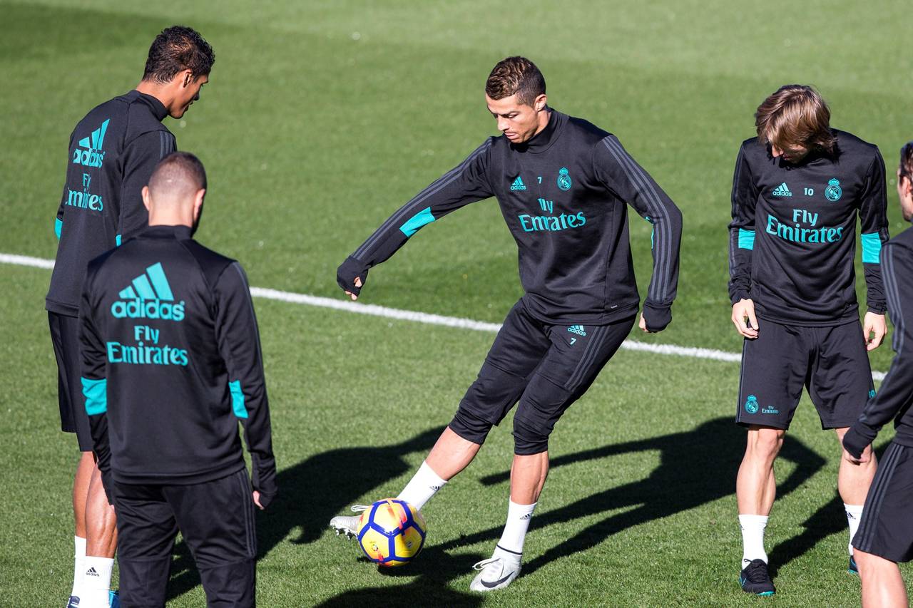 Los jugadores del Real Madrid, el portugués Cristiano Ronaldo (c), el croata Luka Modric (d) y el francés Raphael Varane (i), durante el entrenamiento realizado ayer en la Ciudad Deportiva de Valdebebas. (EFE)