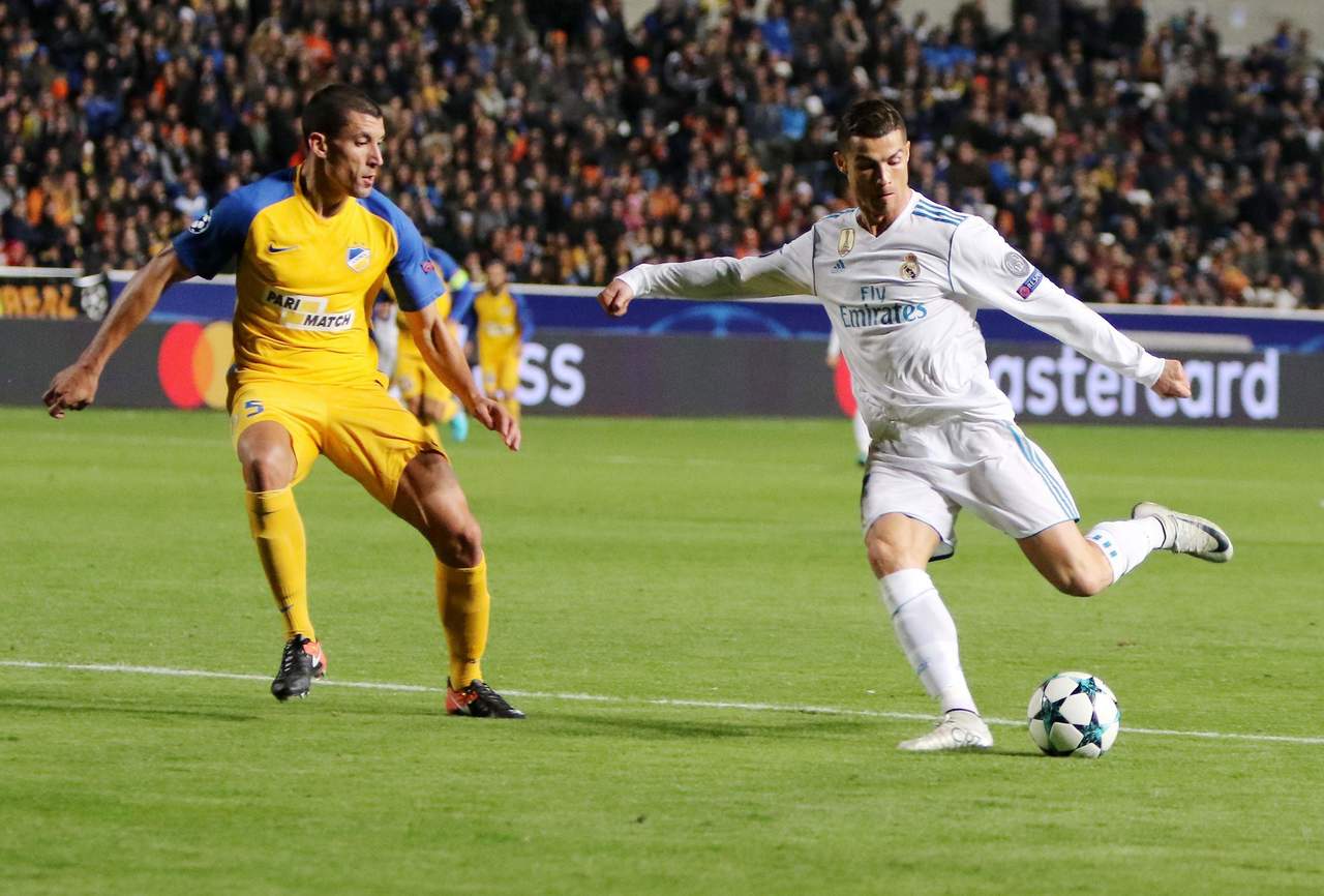 Cristiano Ronaldo (d) conduce el balón ante la marca de Jesús Rueda (i), del Apoel Nicosia, durante un partido entre el Real Madrid y el Apoel Nicosia por el Grupo H de la Liga de Campeones de la UEFA. (EFE)