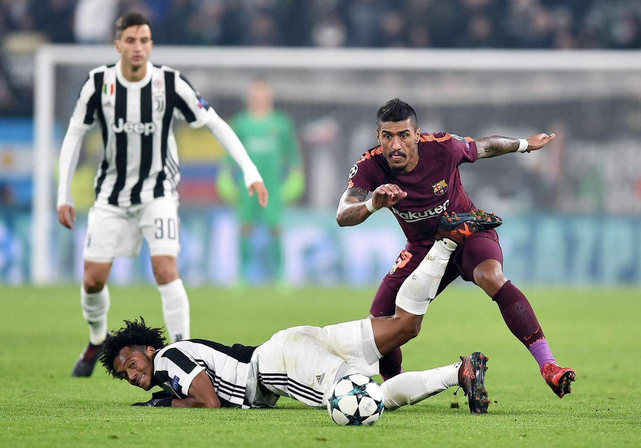 Juan Cuadrado (abajo) cae mientras disputa el balón con Paulinho (d) del Barcelona, durante un partido entre Juventus y Barcelona por el grupo D de la Liga de Campeones de la UEFA, en el estadio Allianz de Turín. (EFE)
