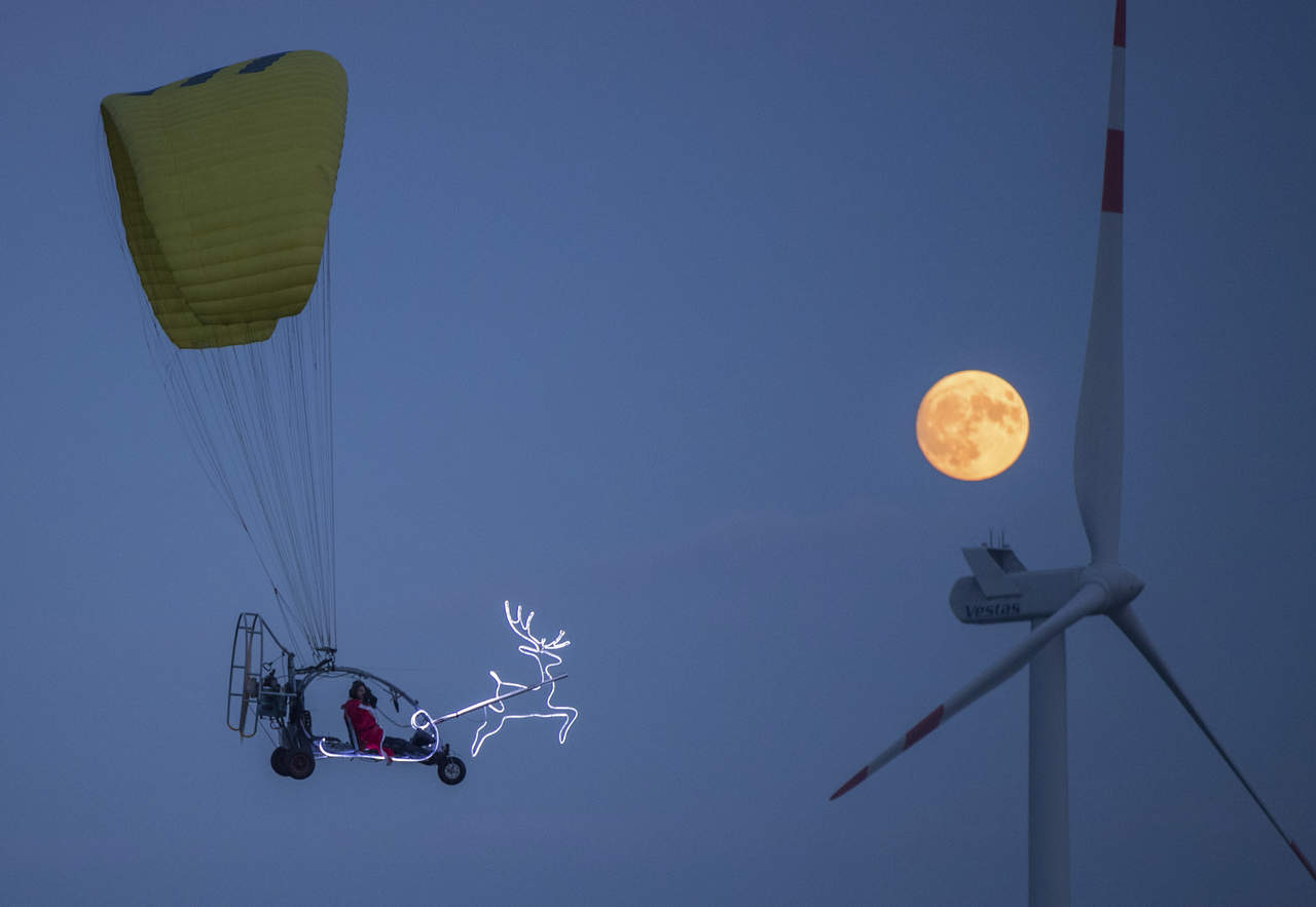 La persigue. Un hombre disfrazado de Santa Claus, voló sobre
Sieversdorf, Alemania, para observar la Super Luna. (AP)