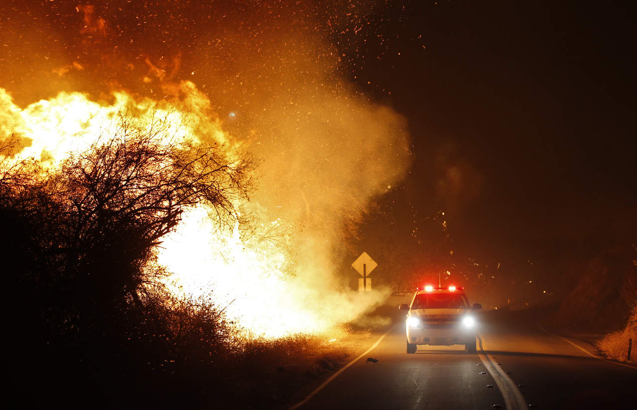 Los vientos de Santa Ana han propiciado que el fuego se extienda rápidamente en la zona comprendida entre la autopista 15 y la ruta estatal 76, por lo que los bomberos piden a la población seguir de cerca el comportamiento de este 'peligroso incendio'. (AP)