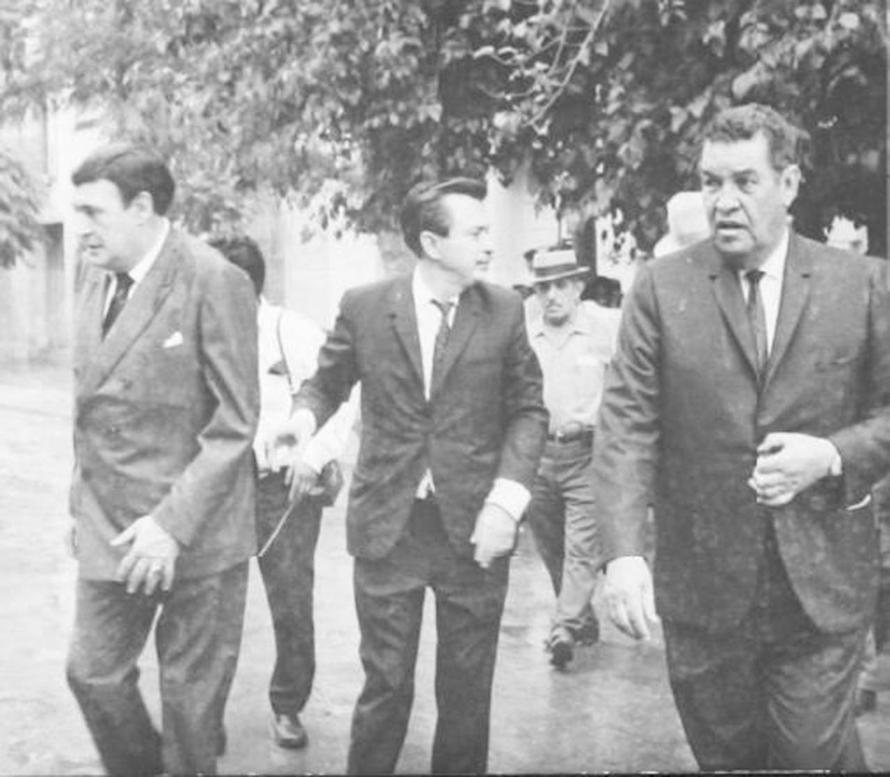 Visita. Concluido la ceremonia, Salvador Novo, Horacio Gutiérrez y Rodolfo Guerrero, atraviesan la calle Ramón Corona entre la llovizna. (Colección del CEHM. Fundación Carlos Slim).
