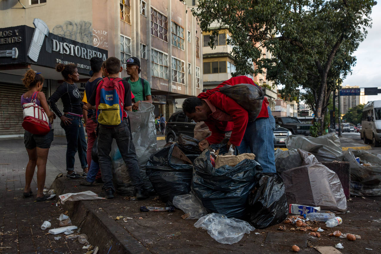 Necesidad. Personas en varias ciudades de Venezuela, han comenzado a buscar comida en la basura. (EFE)