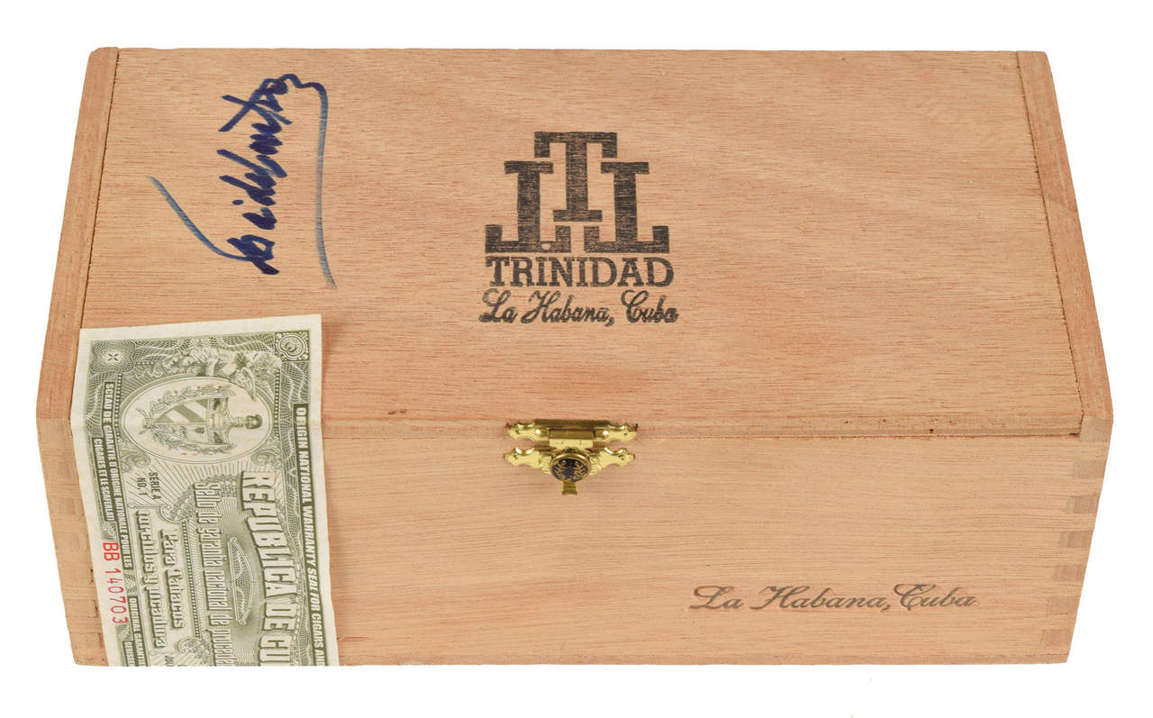 La caja de madera de puros Trinidad Fundadores está firmada en azul por el gobernante cubano. Está acompañada de una foto de Castro firmando la caja para la filántropa doctora Eva Heller en 2002. (EFE)