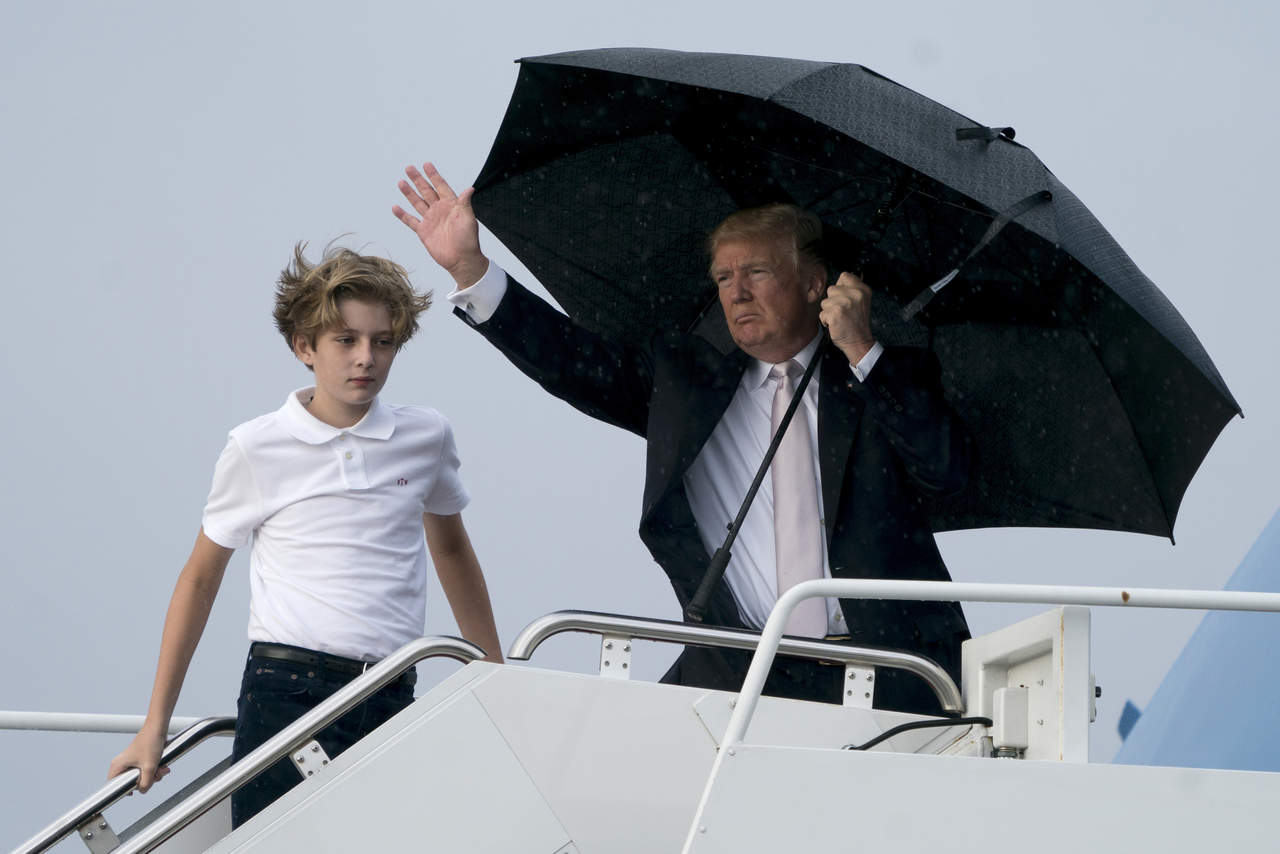 Las cámaras de televisión recogieron el momento en el que el presidente, cubierto con un paraguas, y su familia abordaron el avión Air Force One. (AP)