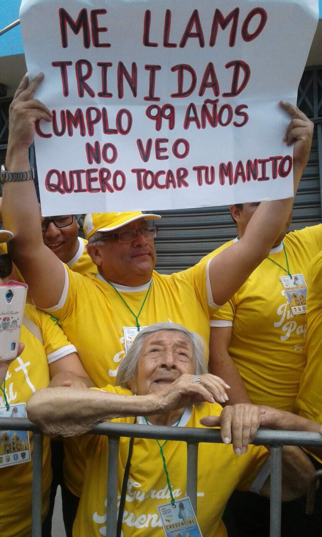 'Me llamo Trinidad cumplo 99 años. No veo. Quiero tocar tu manito', se leía en el cartel que una persona levantaba con el deseo de la anciana en espera de que lo viese el papa a su paso por las calles de Trujillo. (EFE)