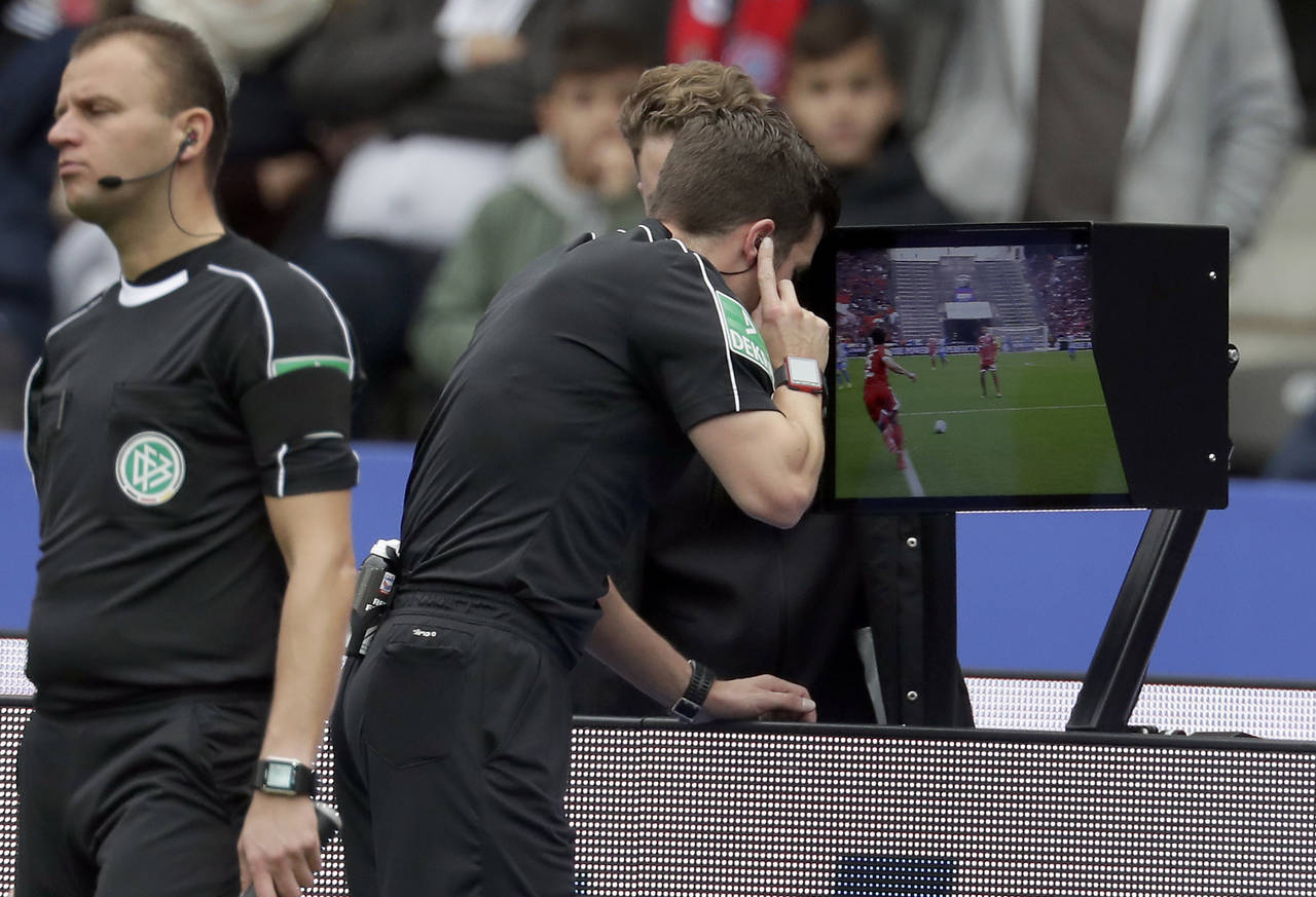 El árbitro Harm Osmers analiza repeticiones en video de una jugada para decidir si concede un penal en un juego de la Bundesliga, en 2017. (AP)