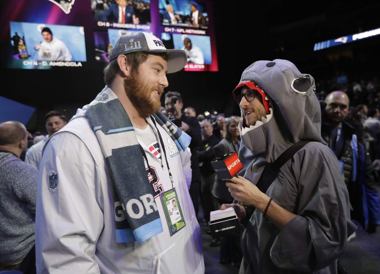 Joe Thuney entrevistado por un reportero con disfraz de tiburón. (AP)